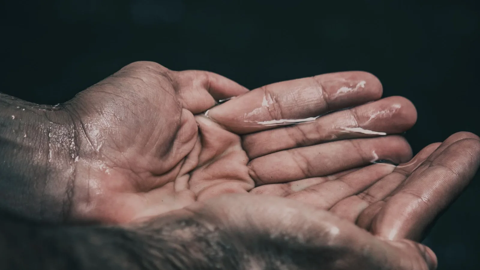 Zu einer Schale geformte Hände, die Wasser halten