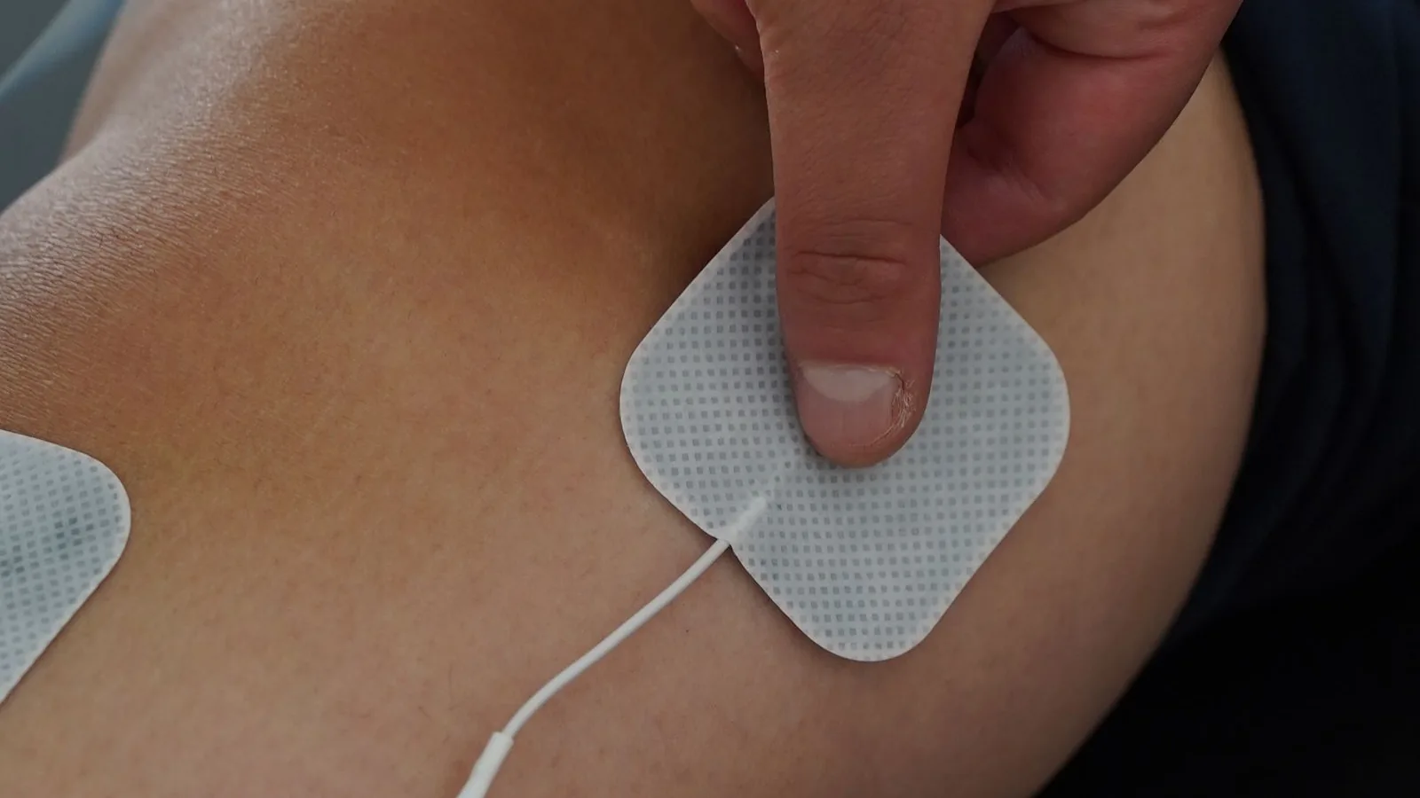 Selbstklebende Elektrode wird auf der Haut angedrückt, Nahaufnahme